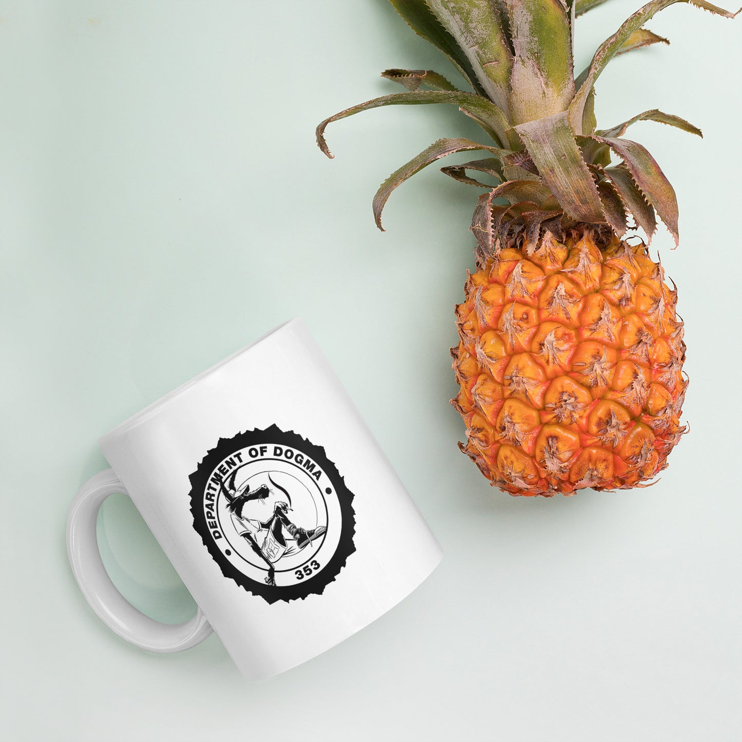 White mug with a black logo and a pineapple on a light green background