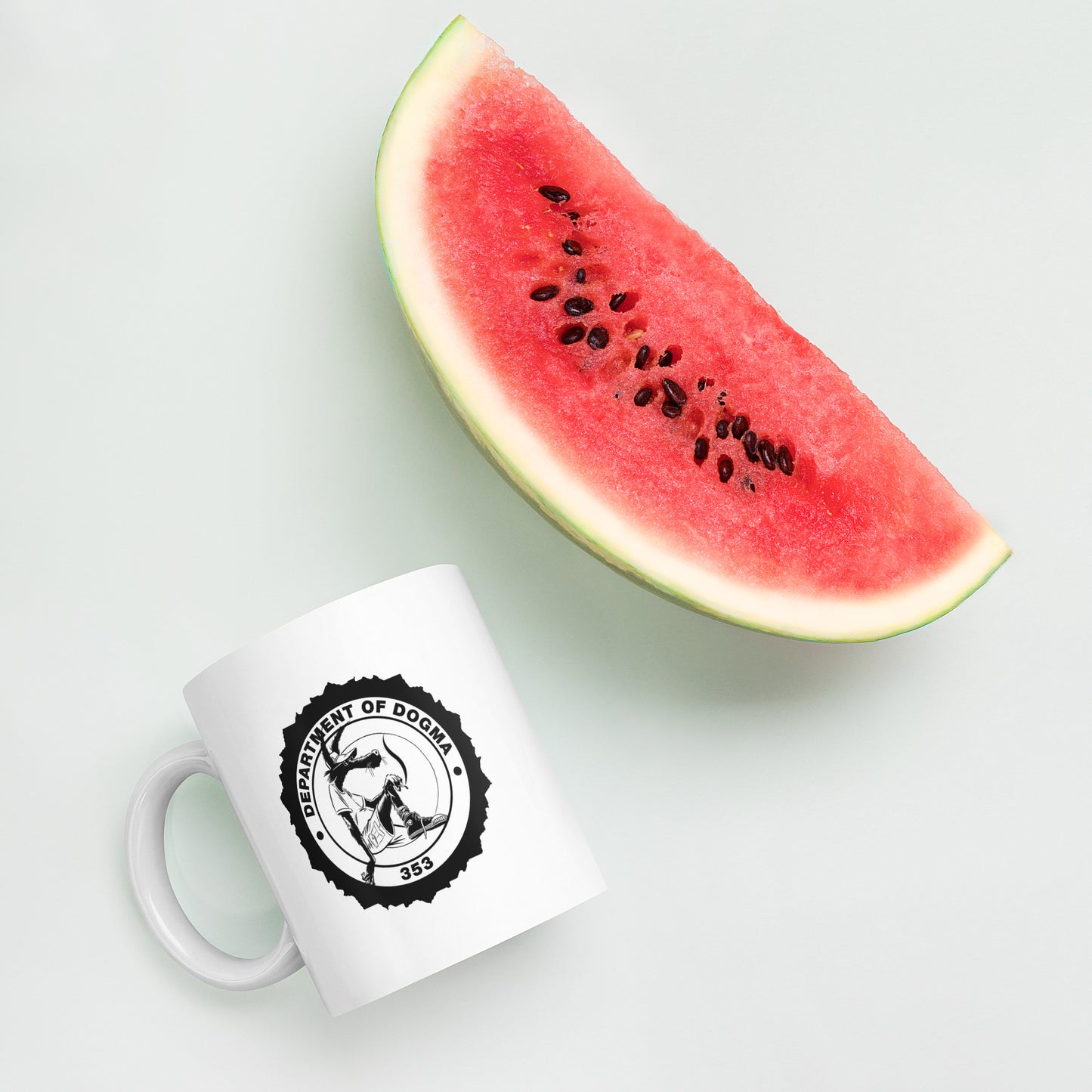 White mug with a black logo next to a slice of watermelon on a light gray background